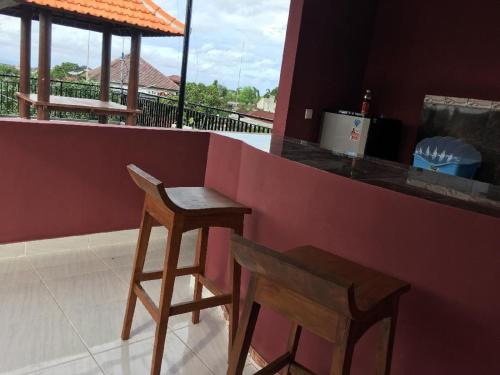 a bar with two wooden stools sitting at a counter at DSTAY Kost Bali in Jimbaran