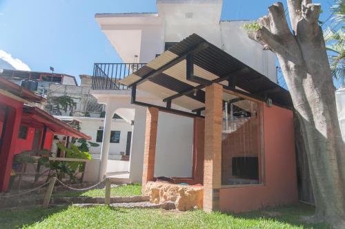 a building with an open door next to a tree at Zoola Resort San Pedro La Laguna in San Pedro La Laguna