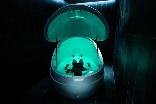 a person swimming in a bowl in a green tub at Skye Niseko in Niseko