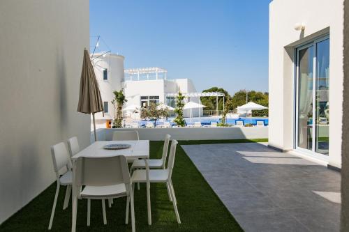 a white dining table and chairs on a patio at Blue Diamond Beach Villas in Paphos City