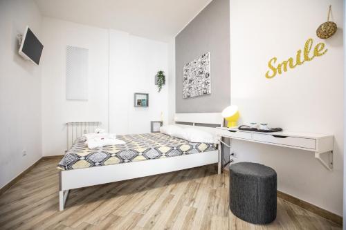 a white bedroom with a bed and a desk at Dolce Vita Affittacamere in Rome