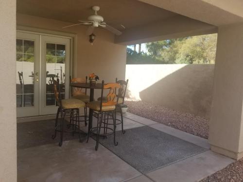 a patio with chairs and a table with a glass door at CLOSE TO STRIP, Very Private, GATED, Huge Floorplan, WIFI, Washer&Dryer in Las Vegas