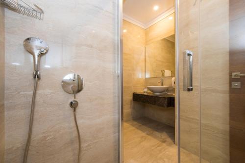 a bathroom with a shower, toilet, and sink at Ramada Plaza Antalya in Antalya