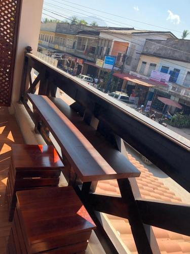 a bench on a balcony with a view of a street at Elephant Boutique Hotel in Luang Prabang