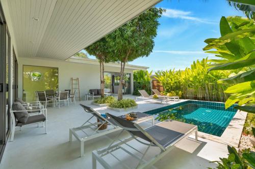 an outdoor patio with a swimming pool and a villa at Villa White Orchid in Choeng Mon Beach