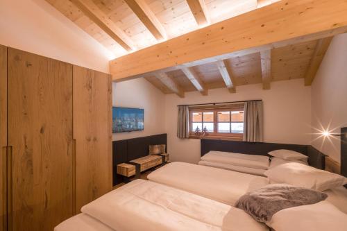 1 dormitorio con 4 camas y techo de madera en Appartement „Hoamatgfühl“ Oberschreitling en Ellmau
