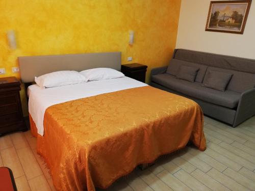 une chambre d'hôtel avec un lit et un canapé dans l'établissement Hotel La Vela, à Boscoreale