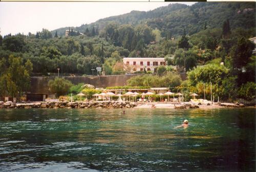a person swimming in the water near a beach at faliraki apartments in Benitses