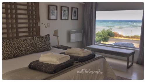 a hotel room with a large window overlooking the ocean at Agulhas Ocean House in Agulhas