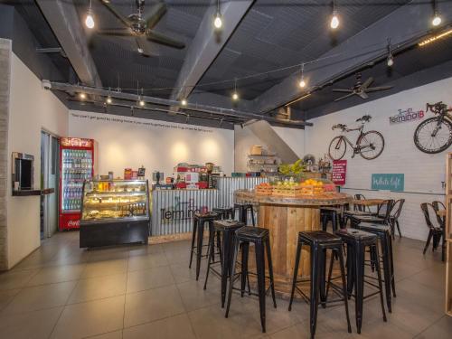 a restaurant with a bar and some stools at White Loft Hotel in Melaka
