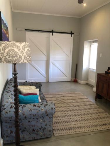 a living room with a couch and a lamp at The Lemon Tree in Prince Albert