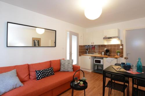 Il comprend un salon avec un canapé orange et une cuisine. dans l'établissement COLMAR city center Little Venise - 