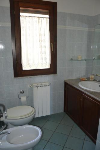 布多尼的住宿－Appartamento Li Puntiti 1，一间带卫生间、水槽和窗户的浴室