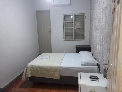 a small bedroom with two beds and a window at Araca Hotel in Araçatuba