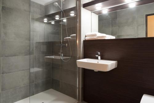 y baño con lavabo y ducha. en Hotel Les Amandiers, en Tournon-sur-Rhône