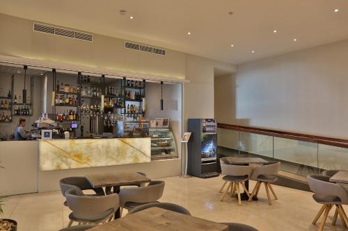 a restaurant with tables and chairs and a bar at Paradise Bay Resort in Mellieħa