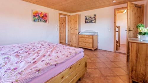ein Schlafzimmer mit einem Bett und einer Kommode in einem Zimmer in der Unterkunft Landhaus Seewald in Seewald