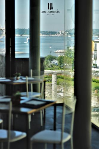 a table and chairs with a view of the water at Hotel Terme Neronensis in Pozzuoli