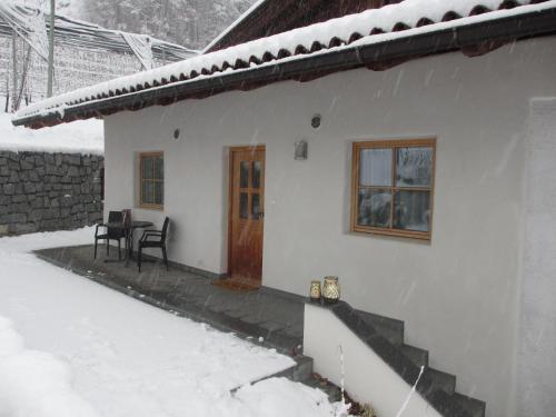 a white house with a table and chairs in the snow at Brugger Hof in Feldthurns