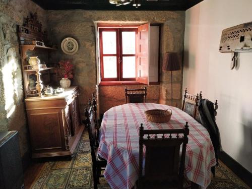 Un comedor con una mesa y una ventana. en Casa da Sicó, en Manteigas