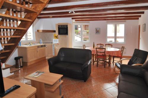 cocina y sala de estar con mesa y sillas en LA MAISON FLEURIE Gîtes du Florimont, en Ingersheim