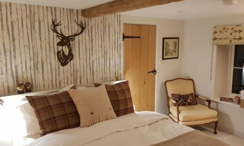 ein Schlafzimmer mit einem Bett mit einem Hirschkopf an der Wand in der Unterkunft Keepers Cottage Guest House in Holt