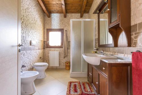 łazienka z umywalką, toaletą i lustrem w obiekcie Villa Pizzi by Perle di Puglia w mieście San Donaci