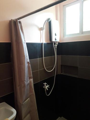 um chuveiro na casa de banho com um WC e uma janela em JPH Resort em Malapascua
