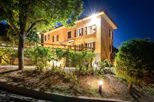 un edificio con un albero di fronte di Villa Vinory - Tenuta il Sogno a San Marzano Oliveto