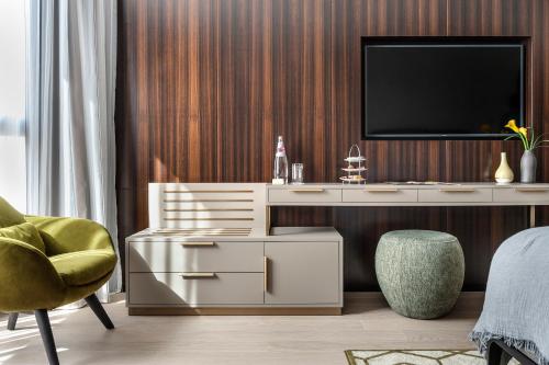 a living room with a desk with a tv on it at The Inbal Jerusalem in Jerusalem