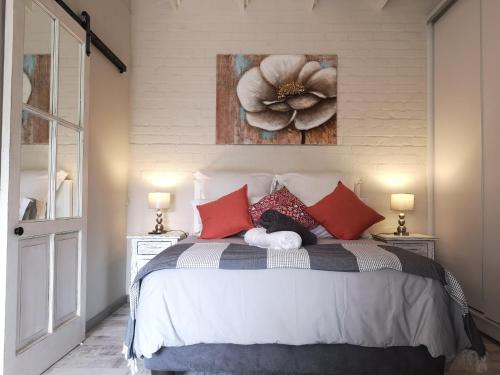 - une chambre avec un lit orné d'une peinture florale sur le mur dans l'établissement RAFTERS COTTAGE, à Plumstead