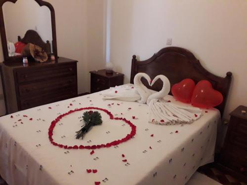 a bed with two swans made out of hearts at Casa Feijao - Alojamento Local in Geres