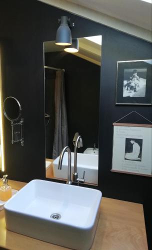 a bathroom with a white sink and a mirror at Naiadi Loft Apartment in Nerezine