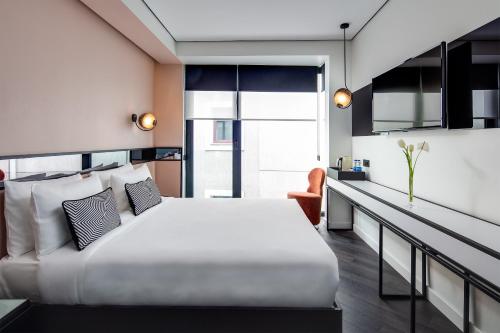 The Westist Hotel & Spa - Special Category في إسطنبول: غرفة نوم مع سرير أبيض كبير ومكتب