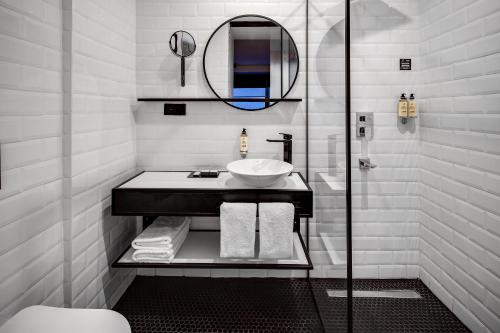 a white bathroom with a sink and a mirror at The Westist Hotel & Spa - Special Category in Istanbul
