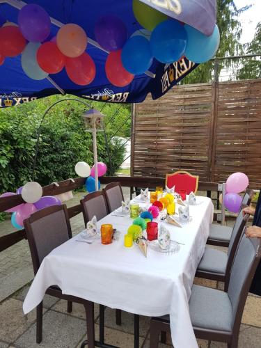 a table with a white table cloth and balloons at Pension New Nomads in Zesch