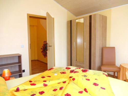 a bedroom with a bed with a flowered blanket on it at Ferienwohnungen Schallerhof in Bischofsgrün