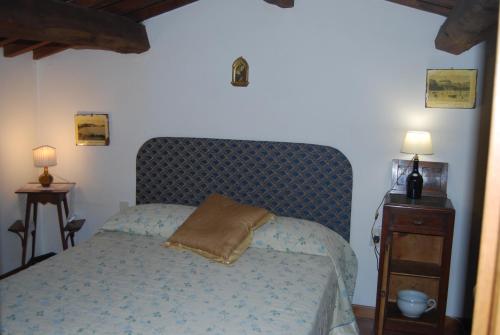 a bedroom with a bed with a blue head board at Ca' Faggiolo in Lamporecchio