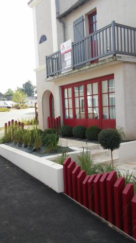 a building with a red fence in front of it at Beauséjour in Sainte-Suzanne