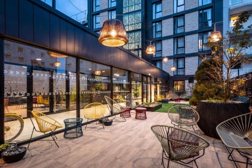 a patio with chairs and tables in a building at voco Strasbourg Centre - The Garden, an IHG Hotel in Strasbourg