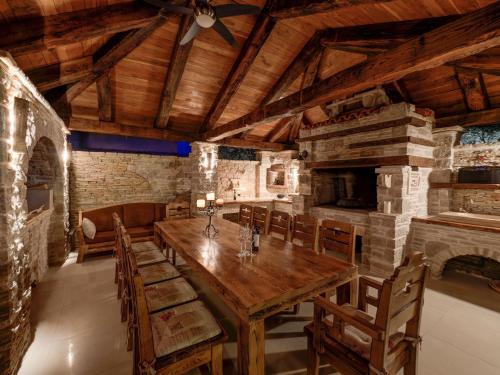 uma sala de jantar com uma mesa de madeira e uma lareira em Modish Apartment in Murter with Bubble Bath em Murter
