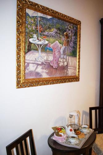 a painting of a woman sitting at a table at B&B La casa D'amare in Maiori