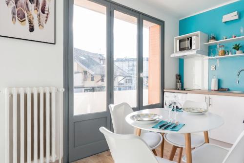 une cuisine et une salle à manger avec une table et des chaises blanches dans l'établissement LP Anne, à Annecy