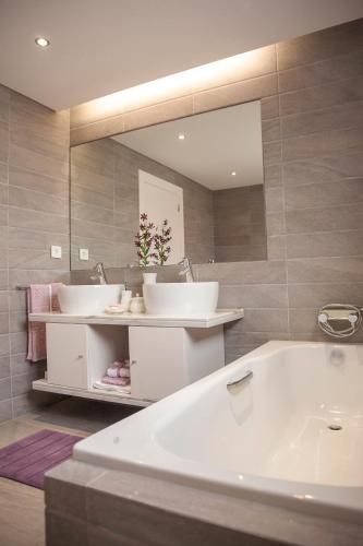 a bathroom with two sinks and a large mirror at Casa do Ácer in São Vicente Ferreira