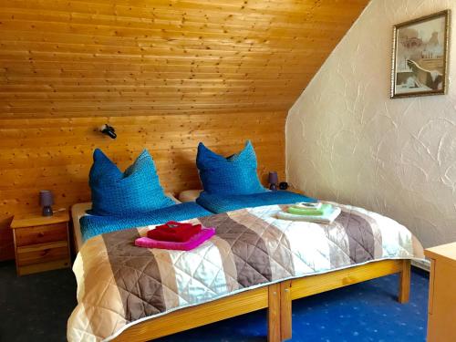 a bedroom with a bed with blue pillows at Ferienwohnung Krallert in Rennertshofen