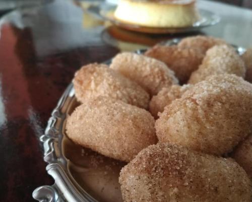a pile of sugar covered donuts in a dish at Pousada da praça in Morro de São Paulo