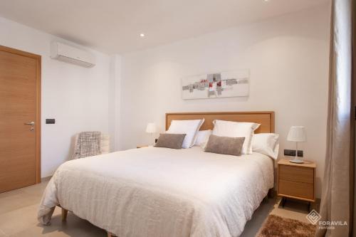a white bedroom with a large bed with two pillows at Ca Na Foc in Sa Pobla