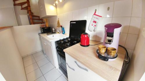 a small kitchen with a stove and a counter top at Maisonette en HYPERCENTRE calme avec terrasse in Cholet