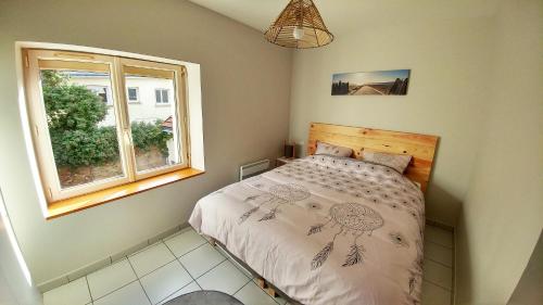 1 dormitorio con cama y ventana en Maisonette en HYPERCENTRE calme avec terrasse, en Cholet