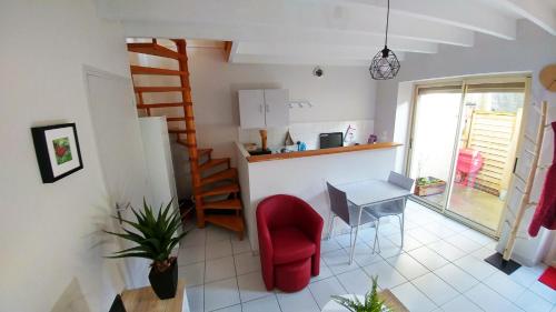 a living room with a red chair and a table at Maisonette en HYPERCENTRE calme avec terrasse in Cholet
